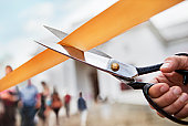 Scissors cutting ribbon, building in background