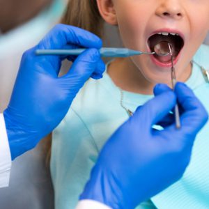 cropped shot of dentist examining teeth of little child