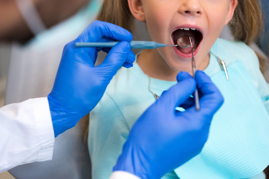 cropped shot of dentist examining teeth of little child