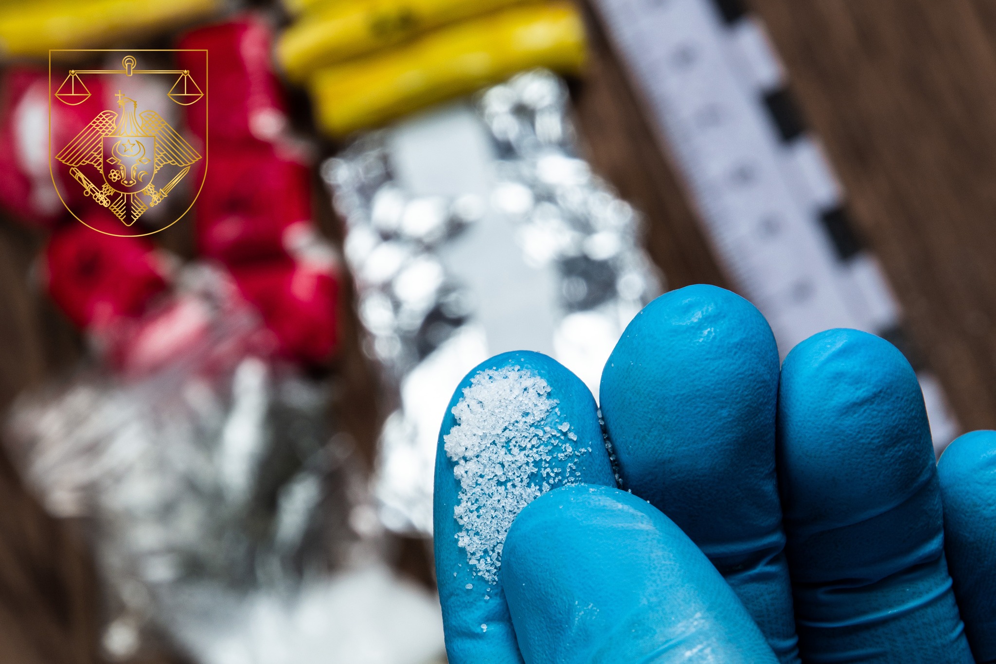 evidence of smuggling traffic: drug powder in the hand of a forensic expert against the background of other arrested materials, cocaine, heroin, spice