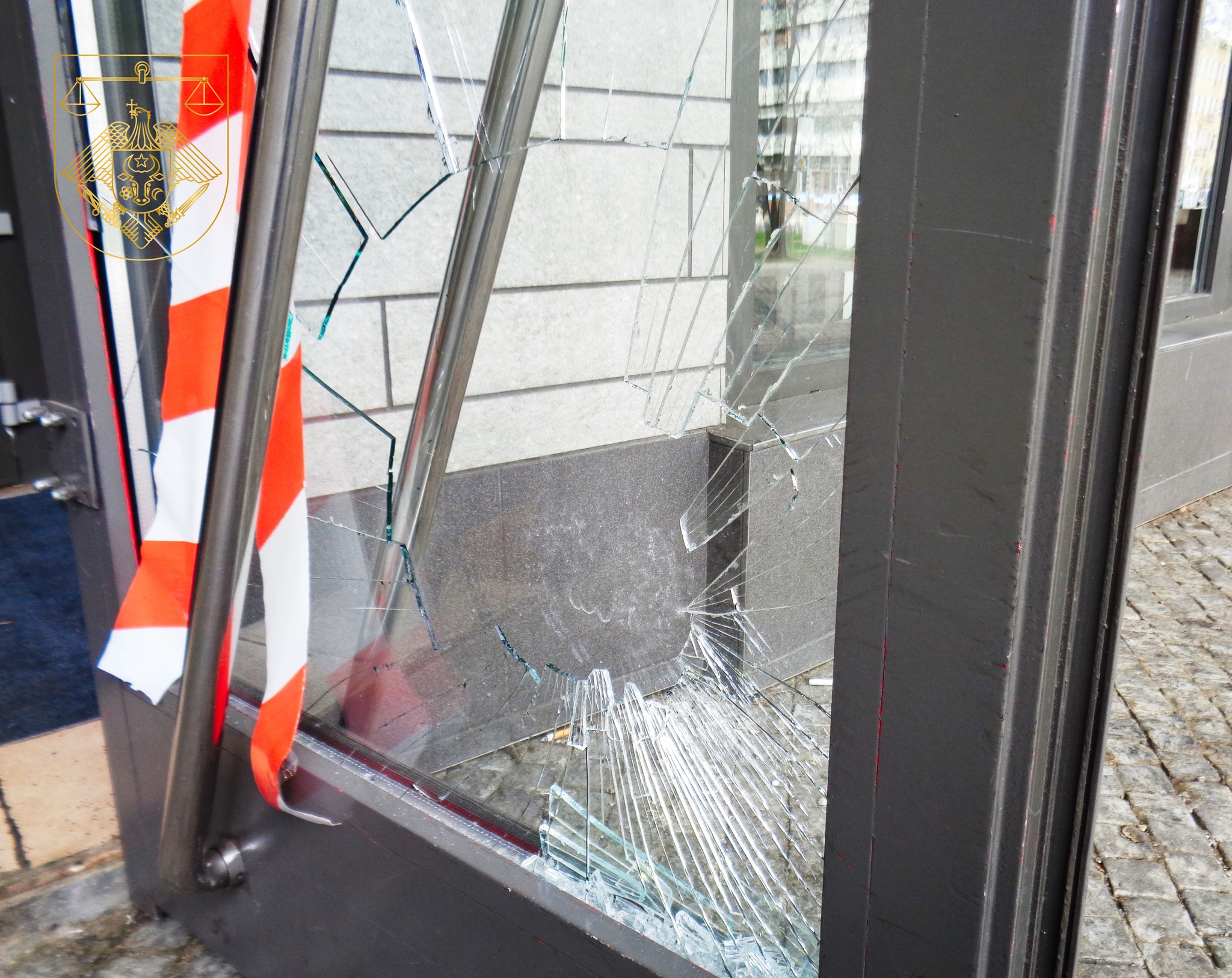 Broken door with shattered glass and barrier tape